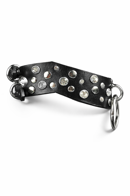 Black leather accessory with silver studs and a ring on a white background