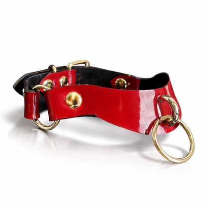 Red leather collar with gold hardware on a white background