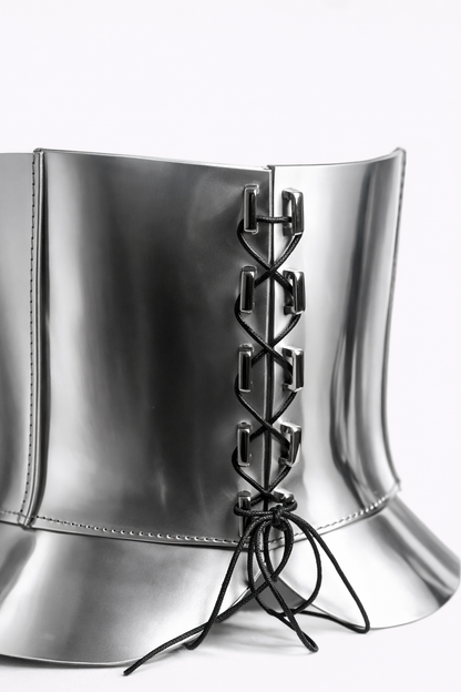 Silver metallic corset with black laces on a white background